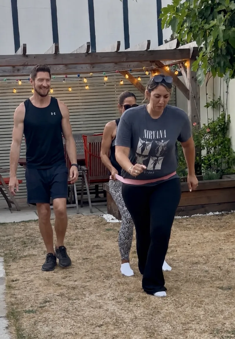 Client dragging a partner in a garden setting